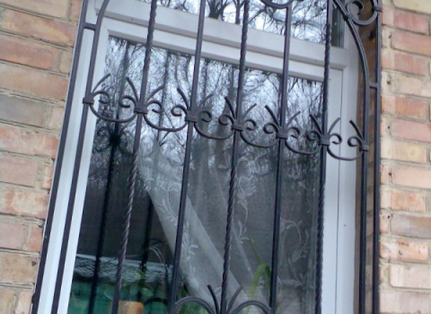 Кованая черная решетка на окно с завитками КР-026